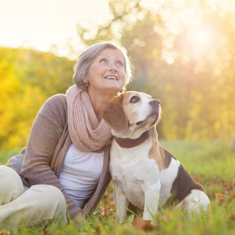 senior woman sitting in the park with her dog